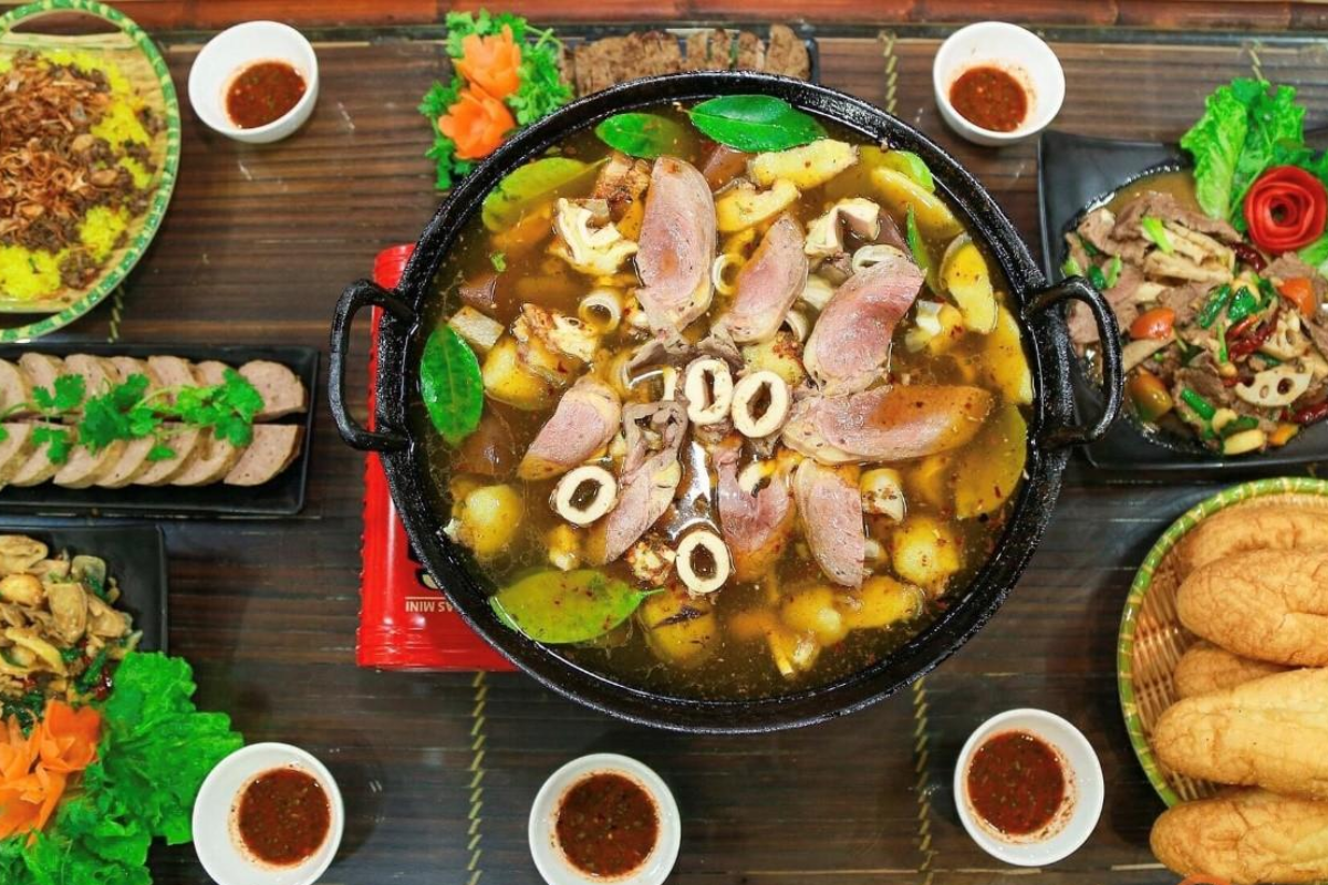 Bowl of Thang Co soup with lemongrass, herbs, and sliced meat in Ha Giang market